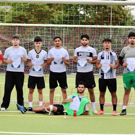 Gruppenfoto der Sieger mit Urkunden auf dem Fußballfeld, stolz vor dem Tor stehend. | © Name