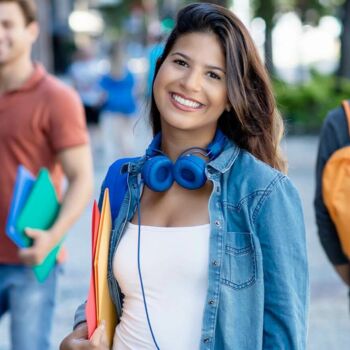 Schülerin der IB Schulen mit blauen Kopfhörern lächelt