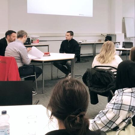 Teilnehmer eines Bewerbertrainings führen ein Vorstellungsgespräch in einem Schulungsraum durch. | © Brillux