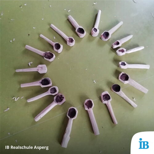 Holzlöffel sind kreisförmig auf einem Tisch im Schullandheim der 8a der Realschule arrangiert.
