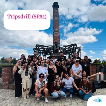 Gruppe von Besuchern posiert fröhlich vor der Attraktion in Tripsdrill unter einem blauen Himmel mit Wolken.