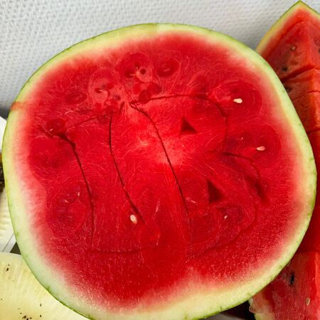 Eine aufgeschnittene Wassermelone mit einer kunstvollen Gravur auf der roten Fruchtseite, bereit zum Genießen.