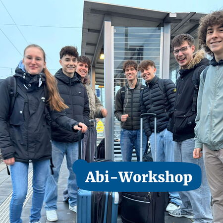 Eine Gruppe von jungen Leuten steht am Bahnhof mit Gepäck und lächelt begeistert für den Abi-Workshop.