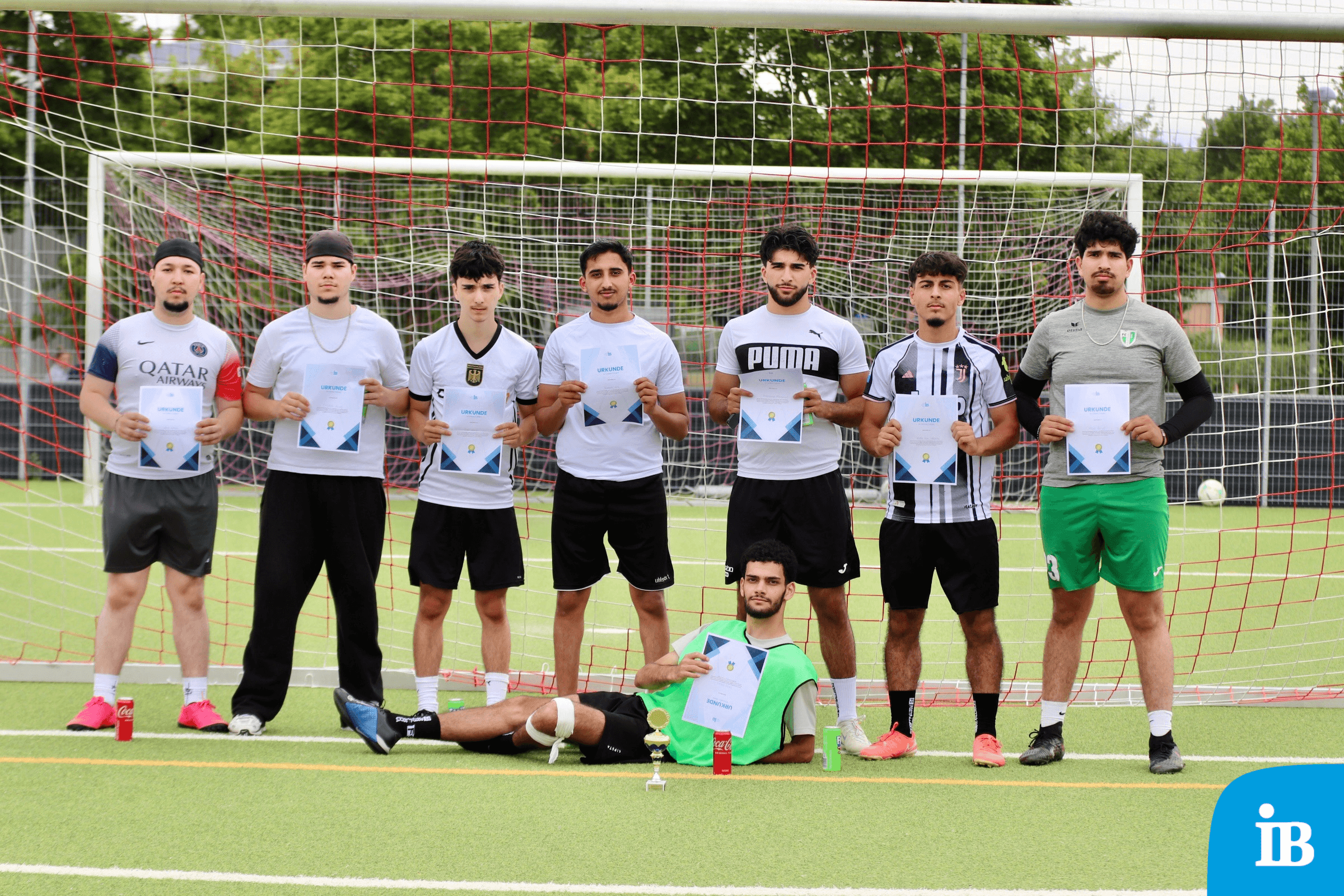 Gruppenfoto der Sieger mit Urkunden auf dem Fußballfeld, stolz vor dem Tor stehend. | © Name