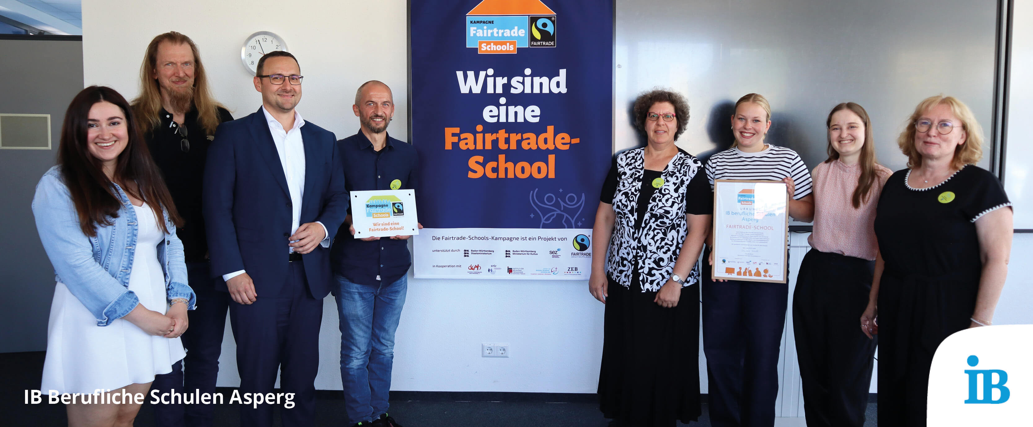 Schüler und Lehrer der IB Schule Asperg feiern die Auszeichnung zur Fairtrade-Schule mit einem Zertifikat.