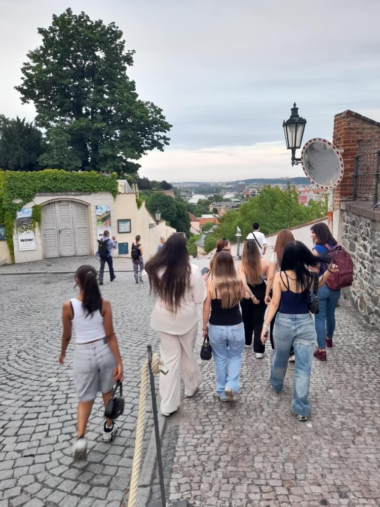 Eine Gruppe von Frauen geht die gepflasterte Straße hinunter und genießt die Aussicht auf die Stadt.