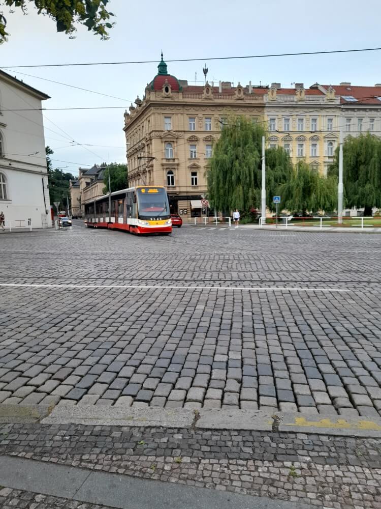 Ein Straßenbahn fährt über den gepflasterten Platz vor historischen Gebäuden im Stadtzentrum.