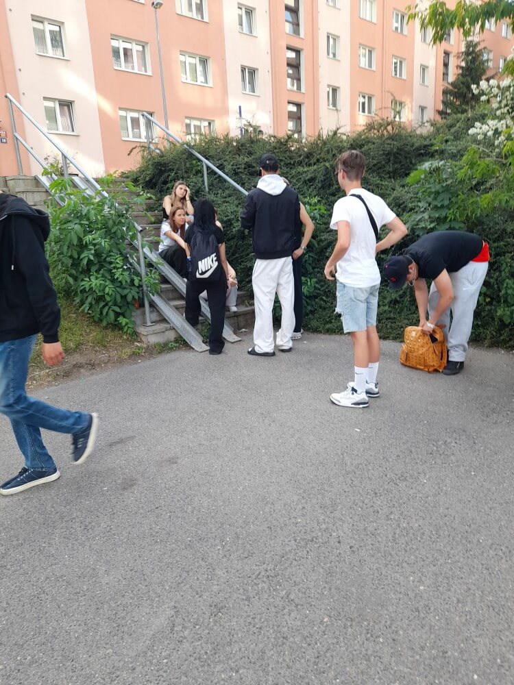 Gruppengespräch auf einer Treppe, während Freunde in sportlicher Kleidung miteinander plaudern und entspannen.