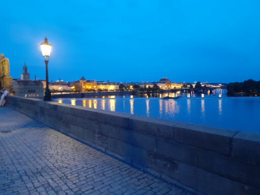 Der beleuchtete Flussuferweg bei Nacht zeigt die schöne Stadtansicht am Wasser.